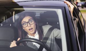 Una donna al volante con faccia sorpresa