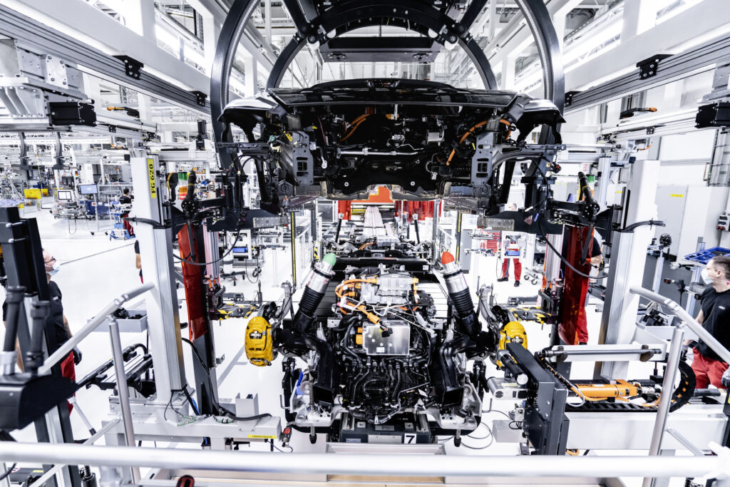 L'impianto di assemblaggio dell'Audi e-tron GT a Böllinger Höfe: i dipendenti fissano la batteria e i componenti della trasmissione alla carrozzeria con viti in 74 punti.