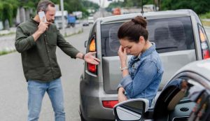 Uomo e donna preoccupati per un incidente tra due auto