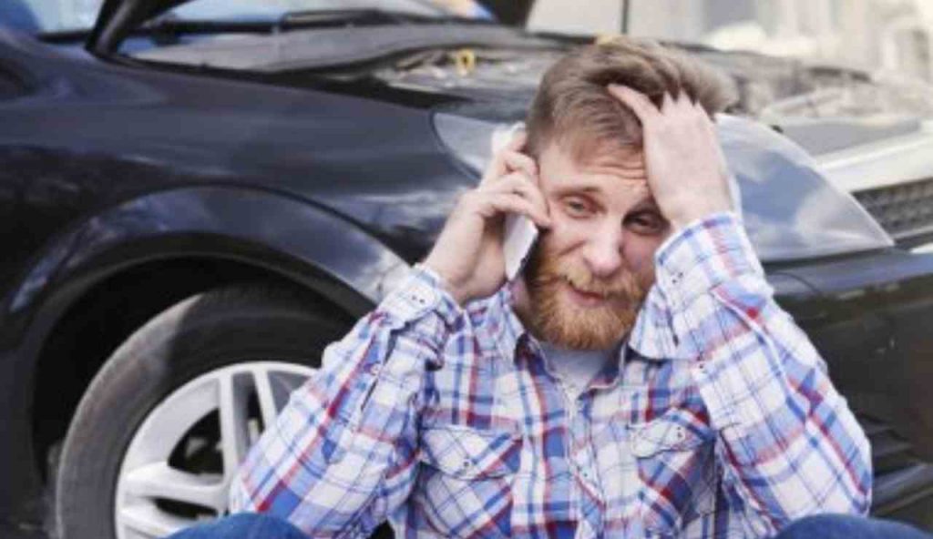 Uomo disperato appoggiato all'auto